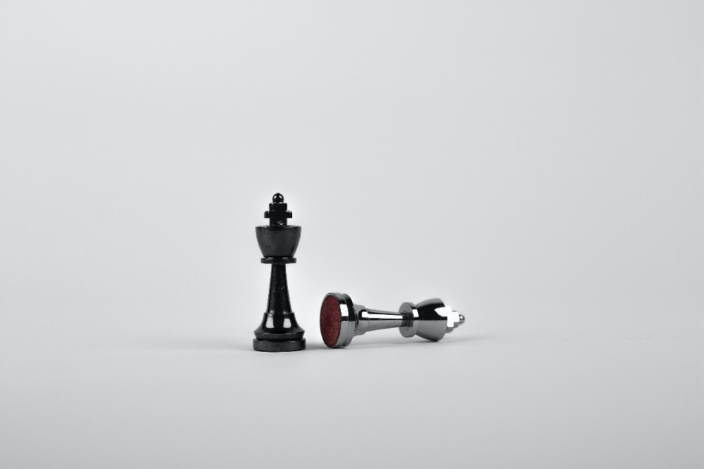 two chess pieces on a white surface
